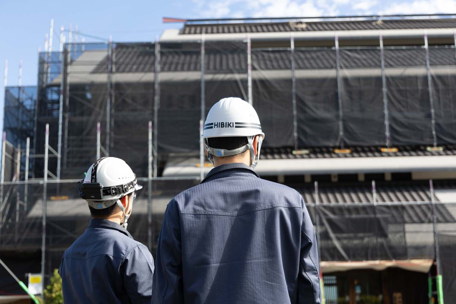 建設現場で施工中の建物を確認する響建設の施工管理スタッフ